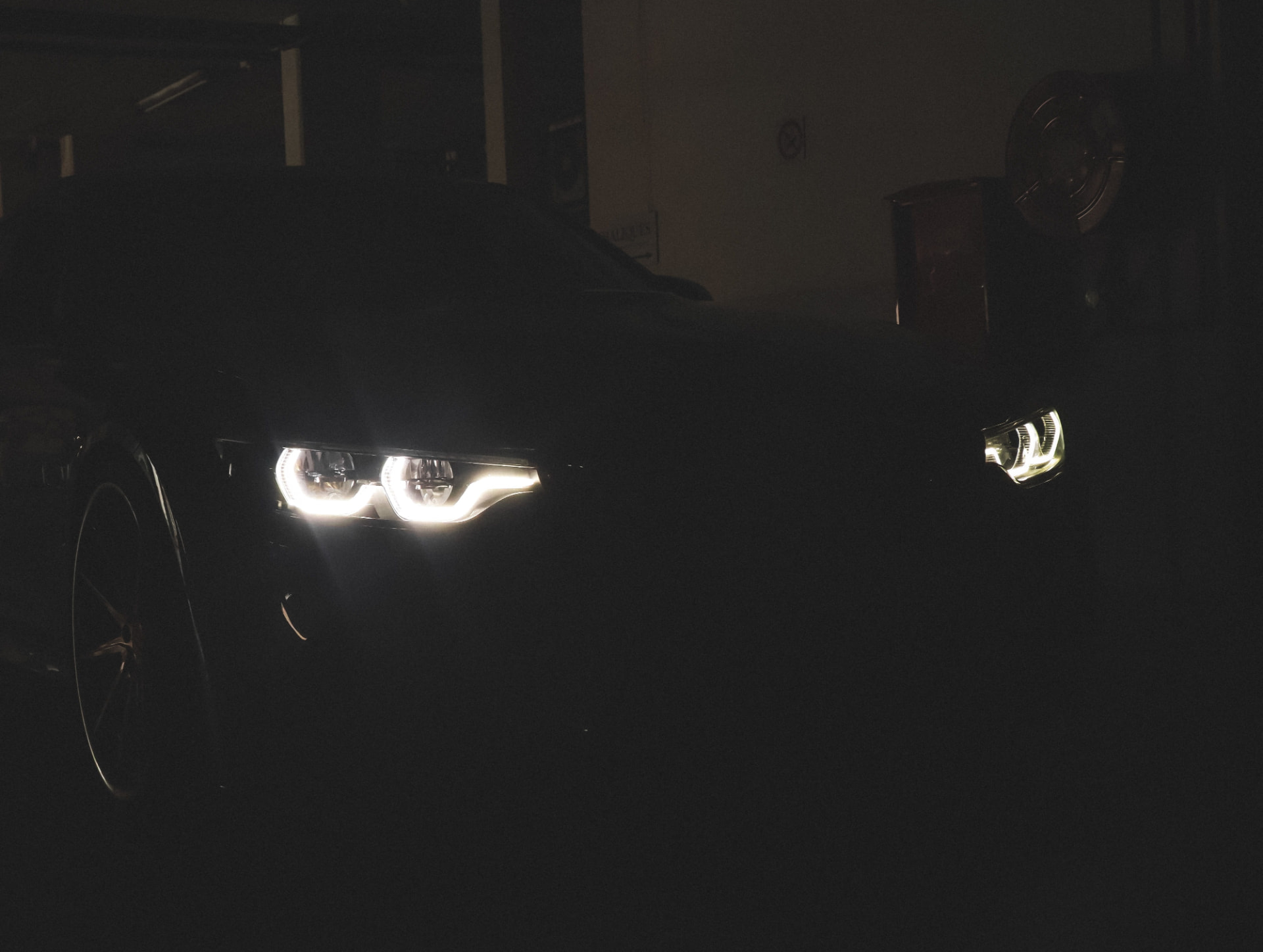 Dark BMW headlights glowing at night